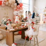 One year old in a Hello Kitty-inspired outfit beside a stylish first birthday party setup